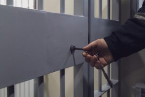 A police officer opening the cell door for an inmate leaving on a bail bond.