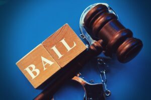 Two blocks that say “bail” next to a gavel and handcuffs. How does a bail bond work?