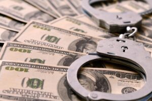 A pair of handcuffs on a stack of cash. How much is bail for a gun charge?
